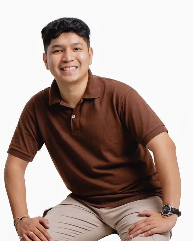 Paul Prado Pacardo seated, smiling, brown polo shirt